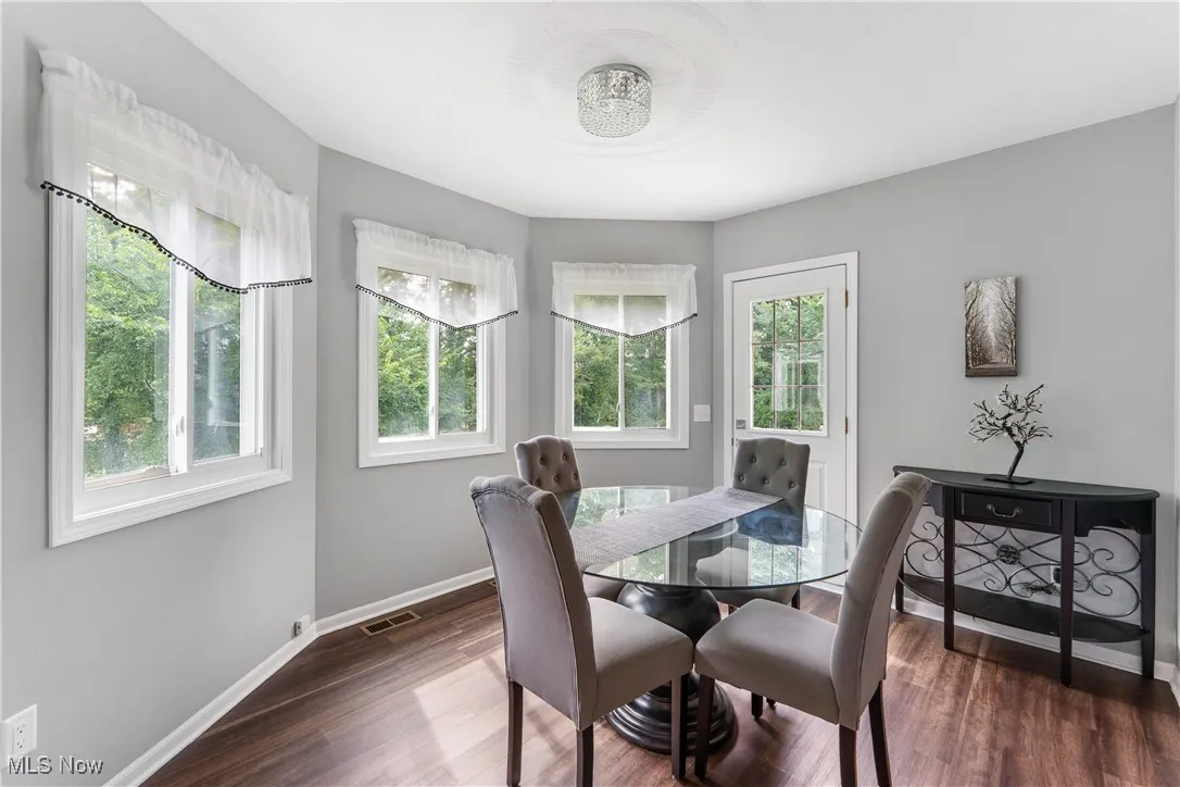 Dining room with dark wood finished floors and baseboards