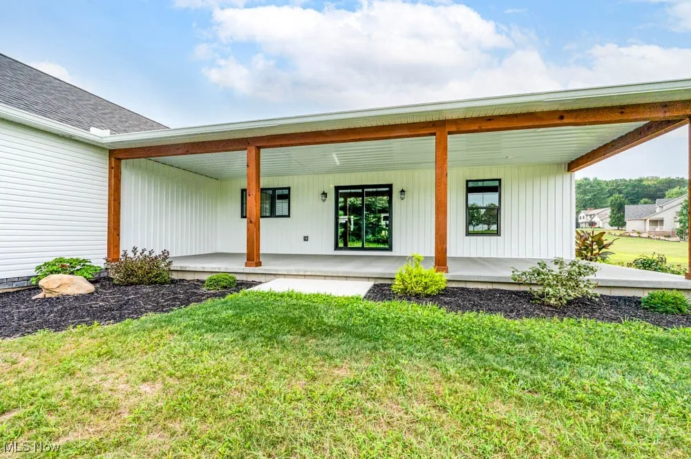 Property entrance with a porch and a lawn