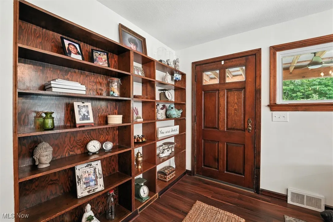 Foyer featuring dark wood finished floors and baseboards