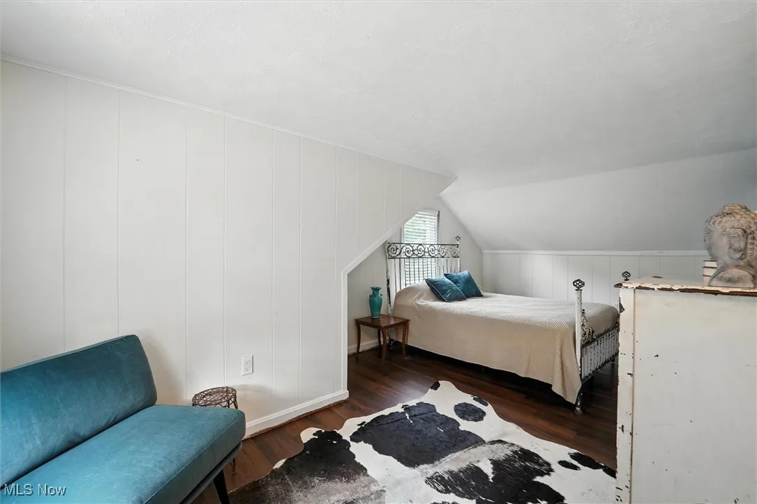Bedroom featuring wood finished floors, a textured ceiling, and lofted ceiling