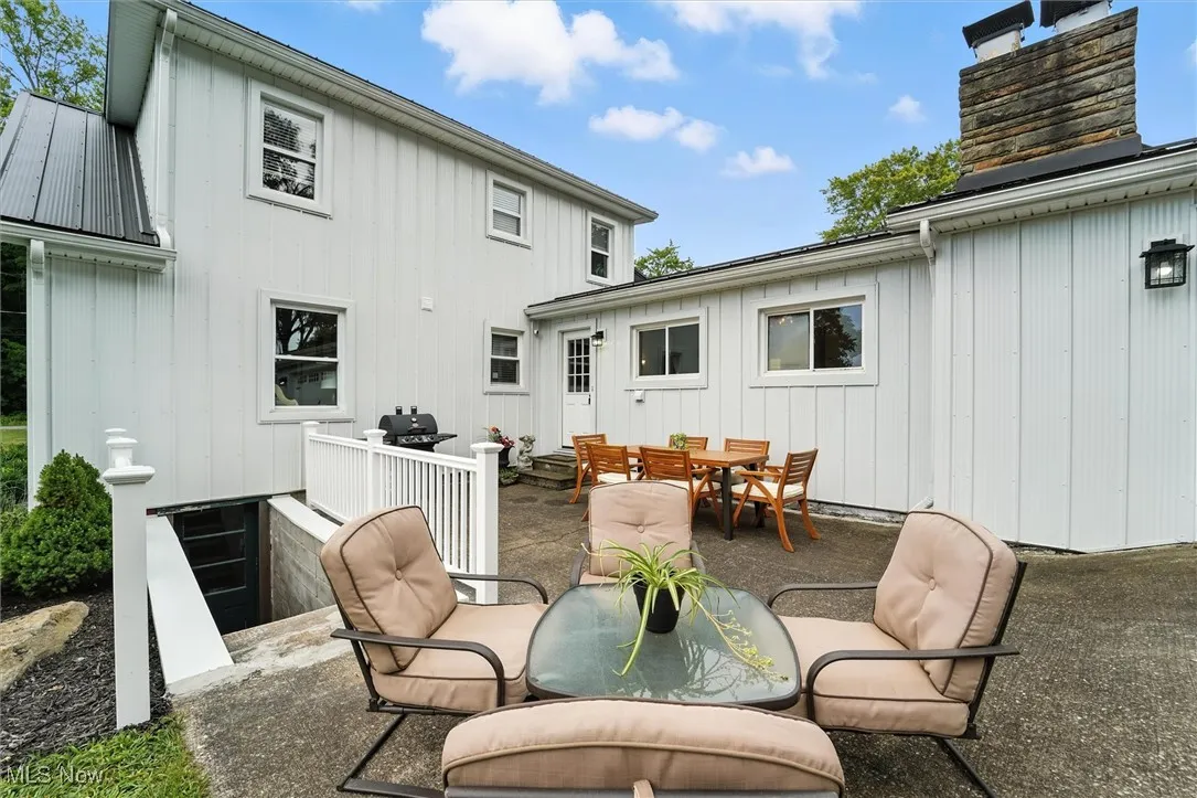 Rear view of property with outdoor dining space, a patio, and board and batten siding