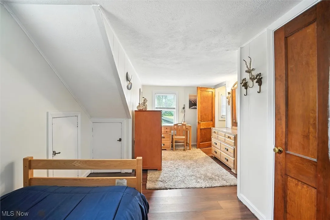 Bedroom featuring a textured ceiling and wood finished floors