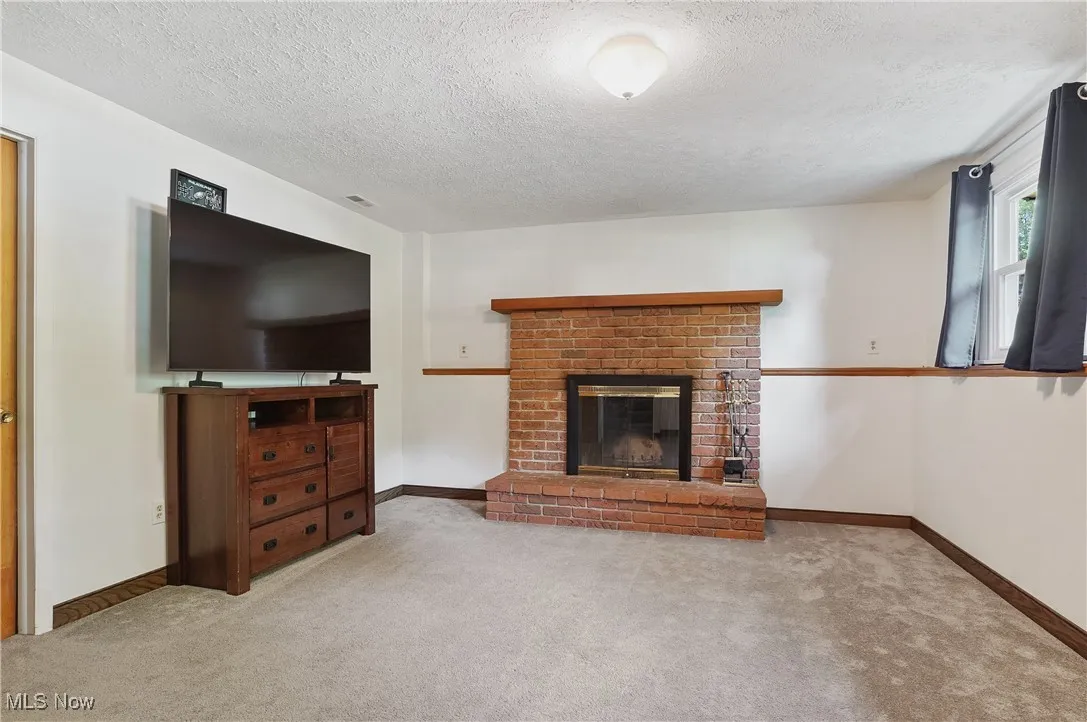 Family room featuring a carpet floors, and a brick fireplace