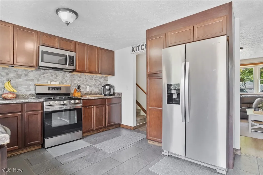 Kitchen featuring stainless steel appliances, decorative backsplash