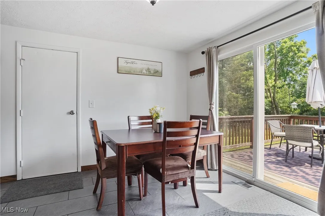 View of tiled dining room with garage and deck access