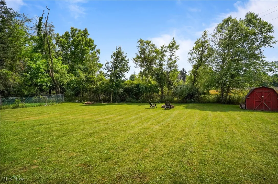 View of yard featuring a storage unit and an outdoor fire pit