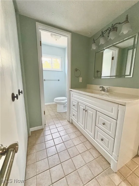 Bathroom featuring vanity, a textured ceiling, and tile patterned flooring