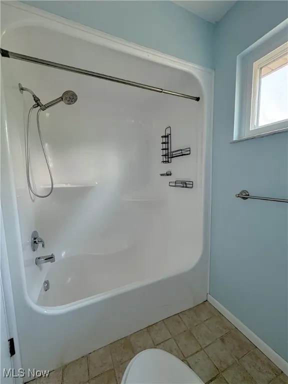 Full bath featuring washtub / shower combination and toilet