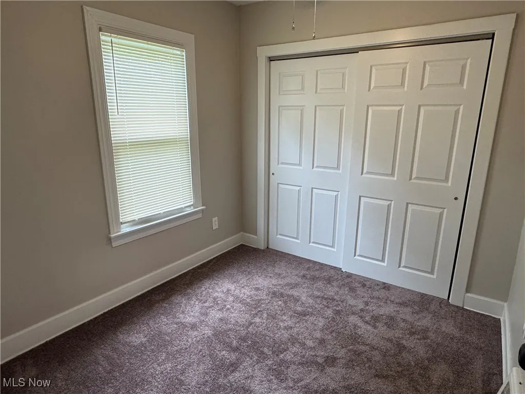 Unfurnished bedroom featuring carpet and a closet