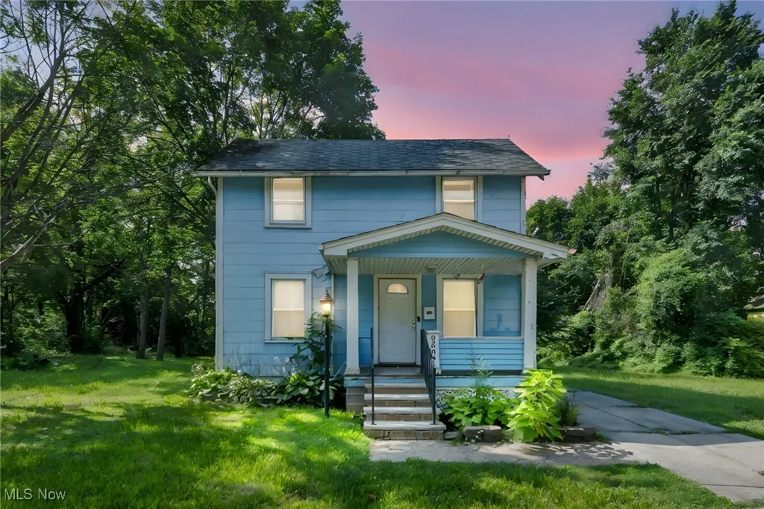 View of front of property with covered porch and a yard