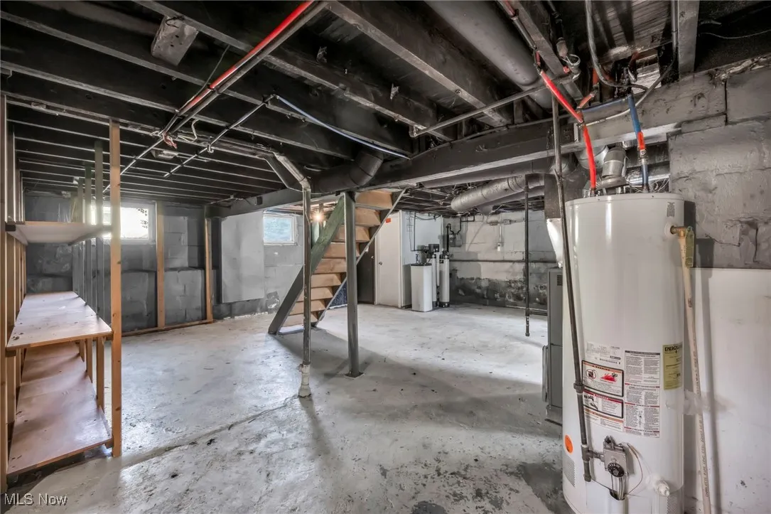 Below grade area with stairway, gas water heater, and a water softener