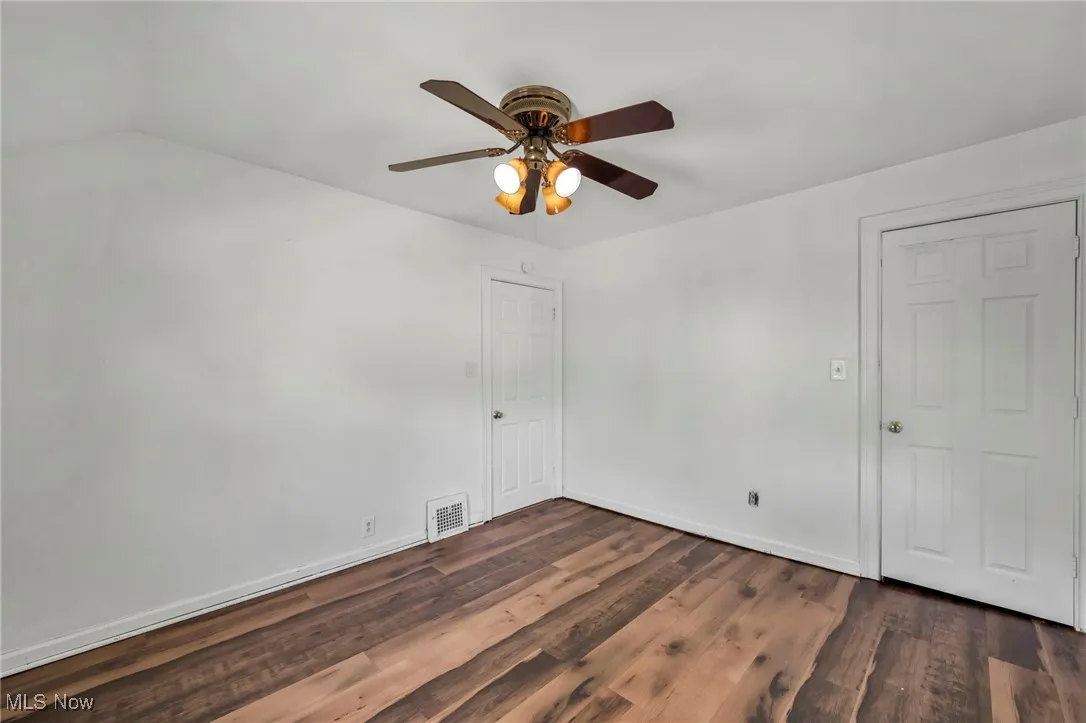 Spare room with wood finished floors and ceiling fan