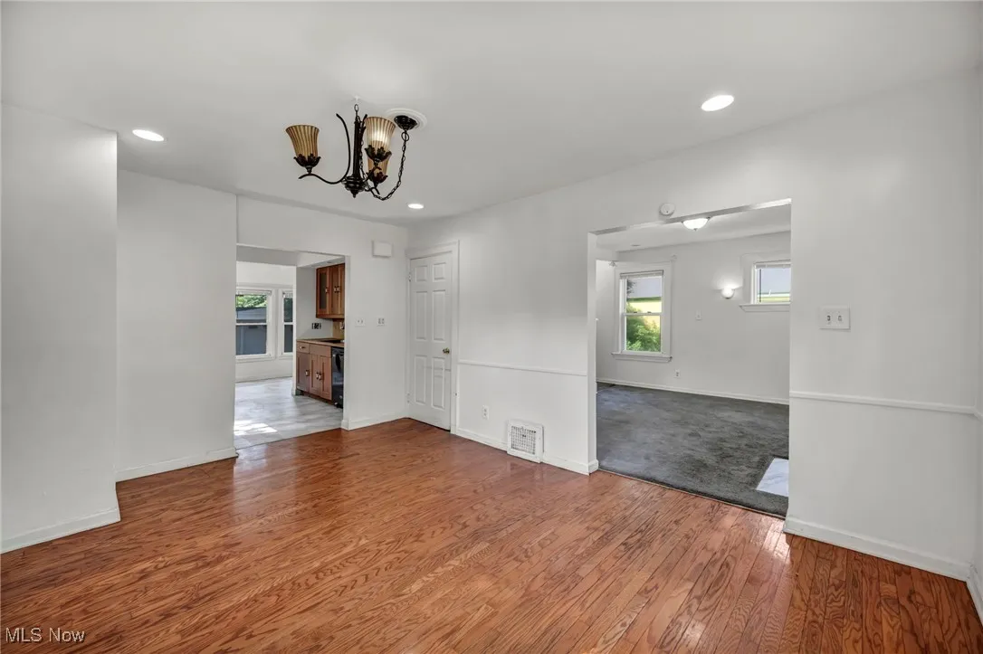 Unfurnished room featuring wood finished floors, a chandelier, and recessed lighting