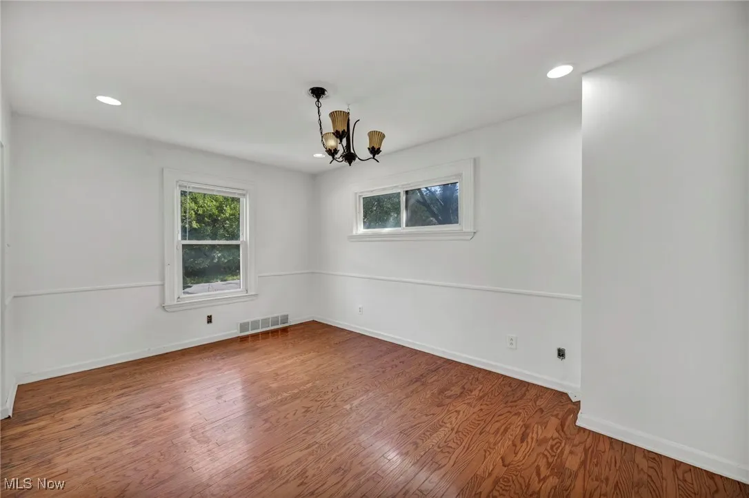 Unfurnished room featuring wood finished floors, a chandelier, and recessed lighting