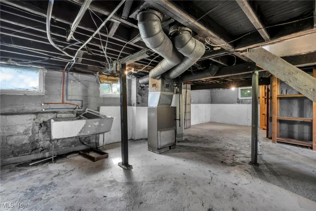 Basement featuring water heater and heating unit