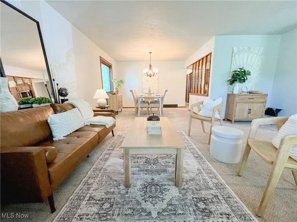 Living area with light carpet and a chandelier