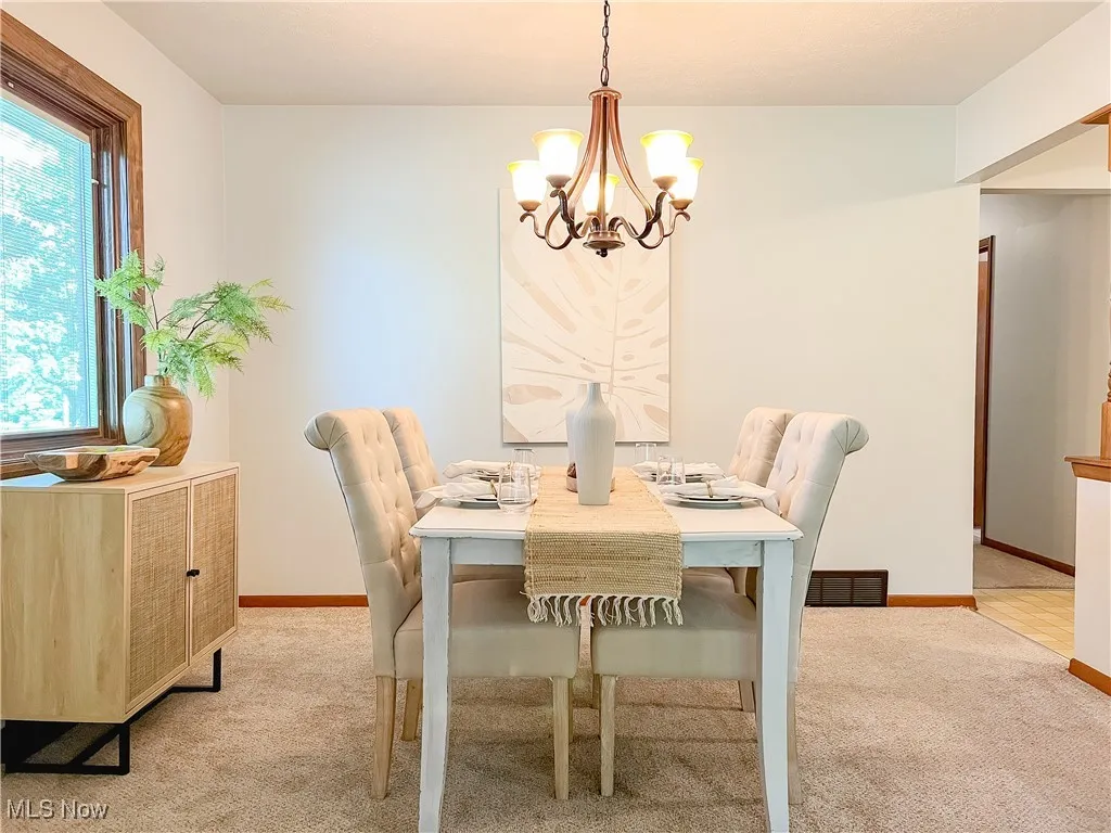 Dining room featuring a chandelier and light carpet