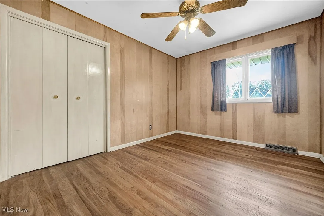 Bedroom with wood finished floors, a closet, and ceiling fan