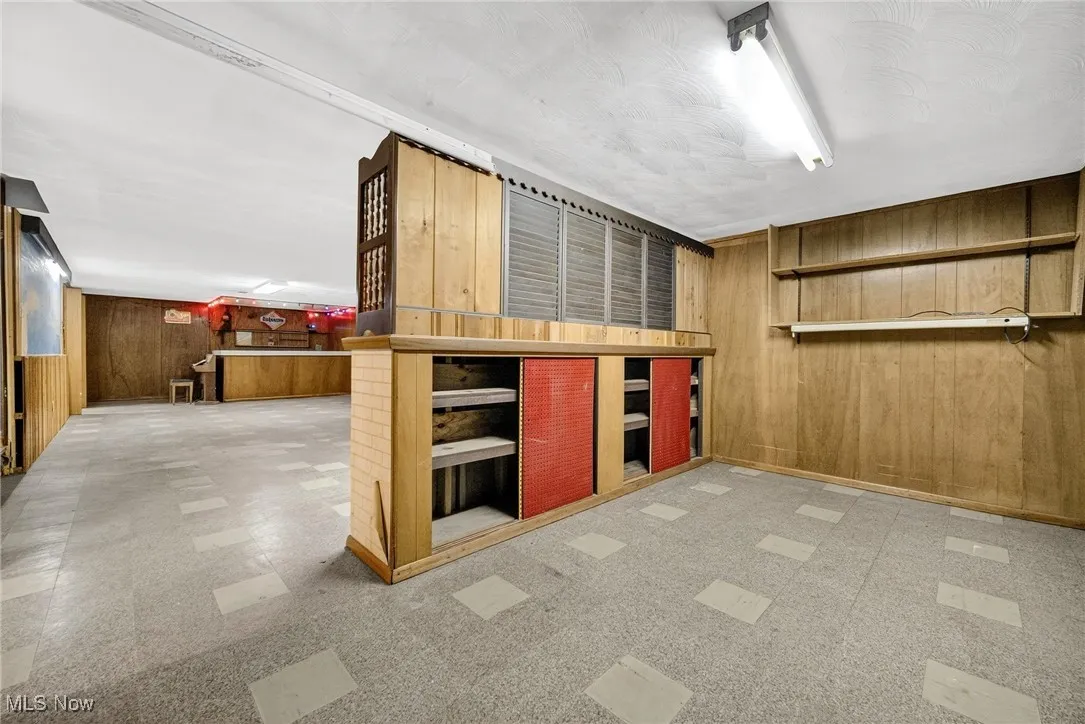 Finished basement with wooden walls and tile patterned floors