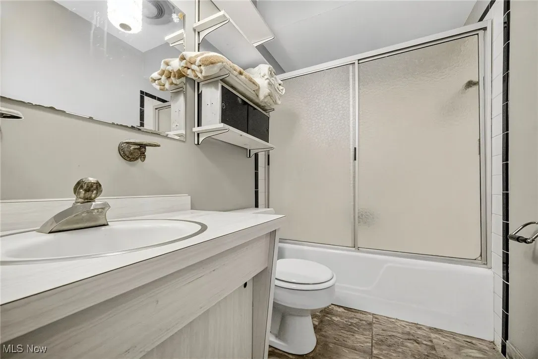 Full bath with vanity and combined bath / shower with glass door, off of  5th bedroom, office or possible In-Law Suite