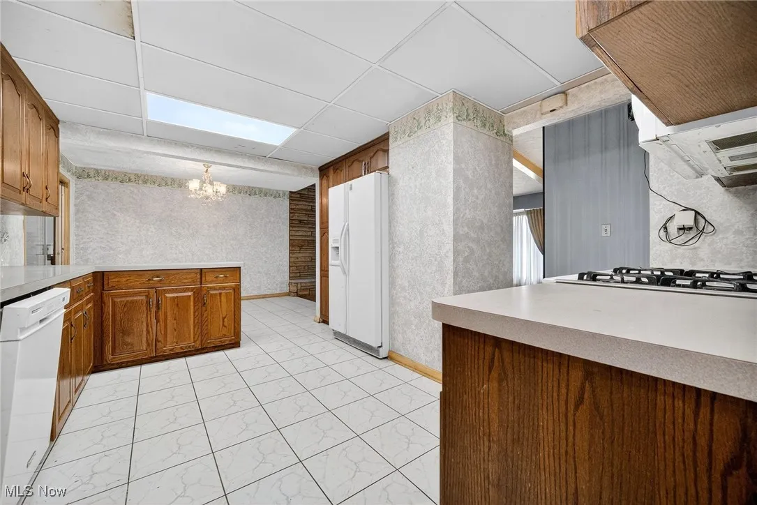 Huge Kitchen with dining area, white appliances, and light countertops.