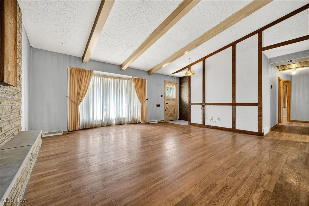 Living Room featuring wood finished floors and a textured cathedral ceiling.