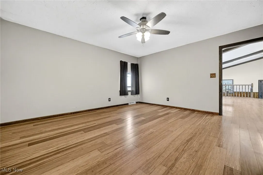 Primary Bedroom with bamboo wood-style floors, a textured ceiling, a ceiling fan.
