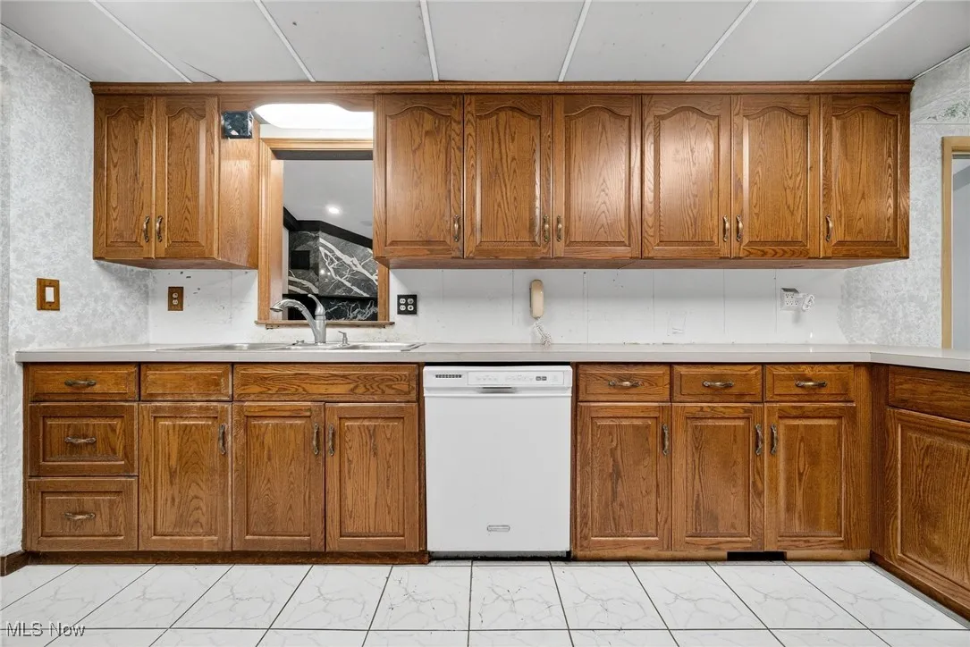 Kitchen with light ceramic  finish floors and dishwasher.