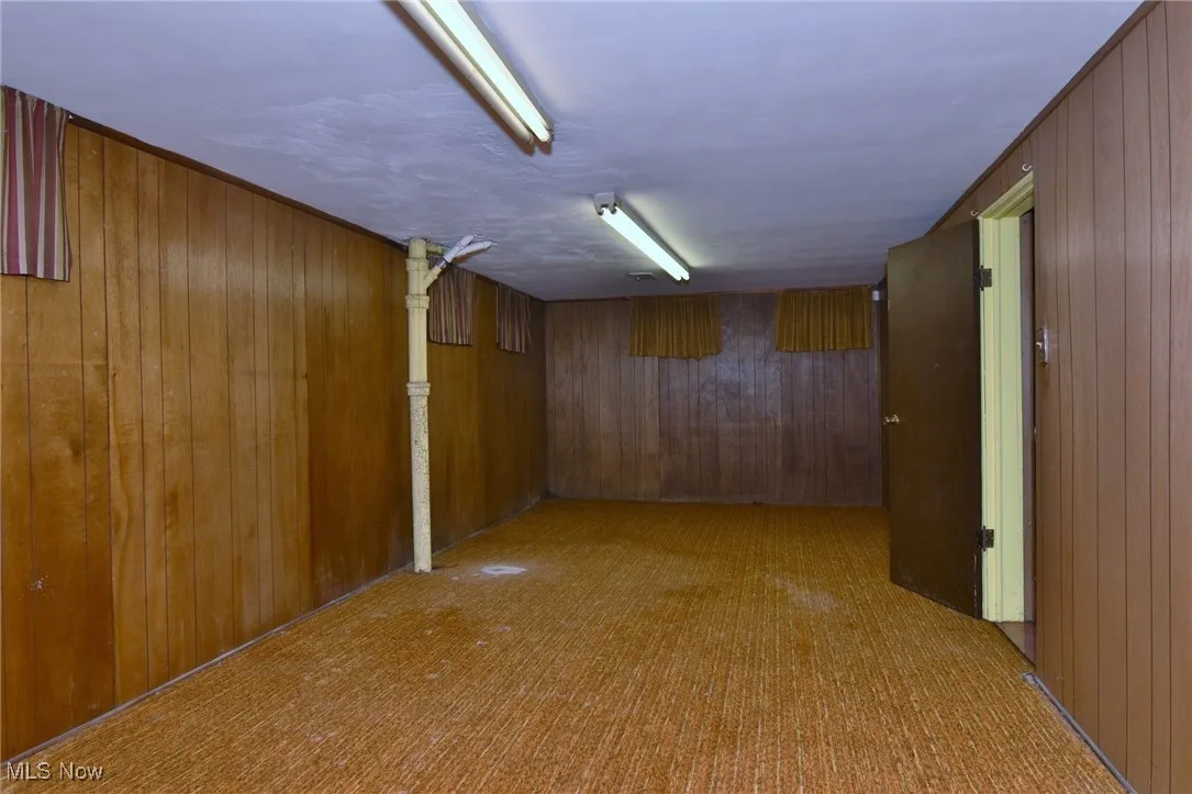 Finished below grade area with wood peneled walls and carpet floors