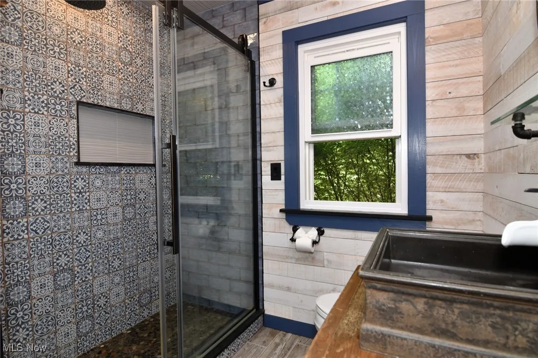Bathroom with a shower stall and wood finished floors