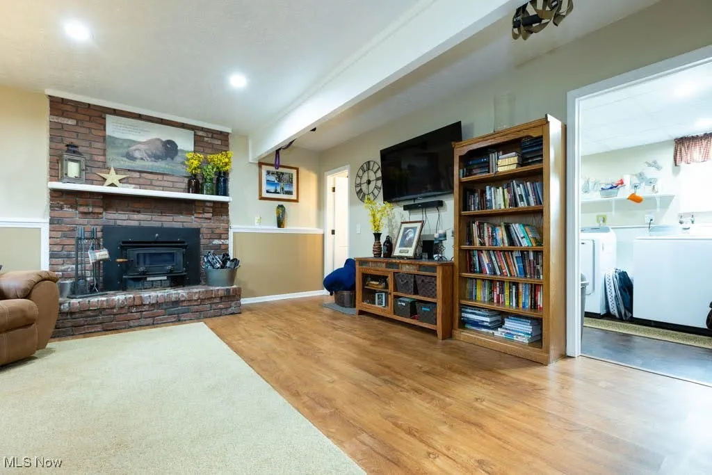 Living area featuring washer and dryer, wood finished floors, and recessed lighting