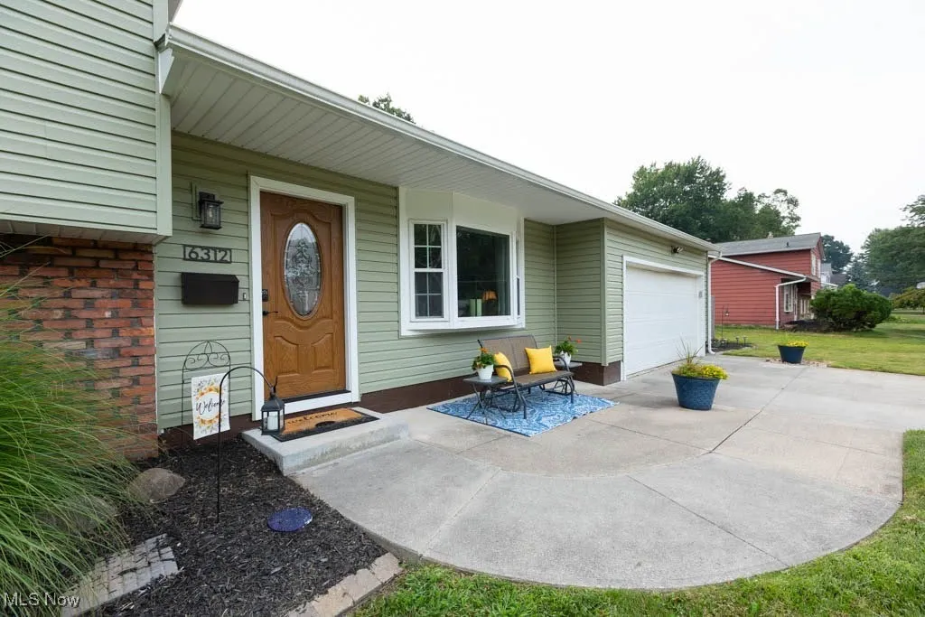 View of exterior entry featuring driveway and a garage