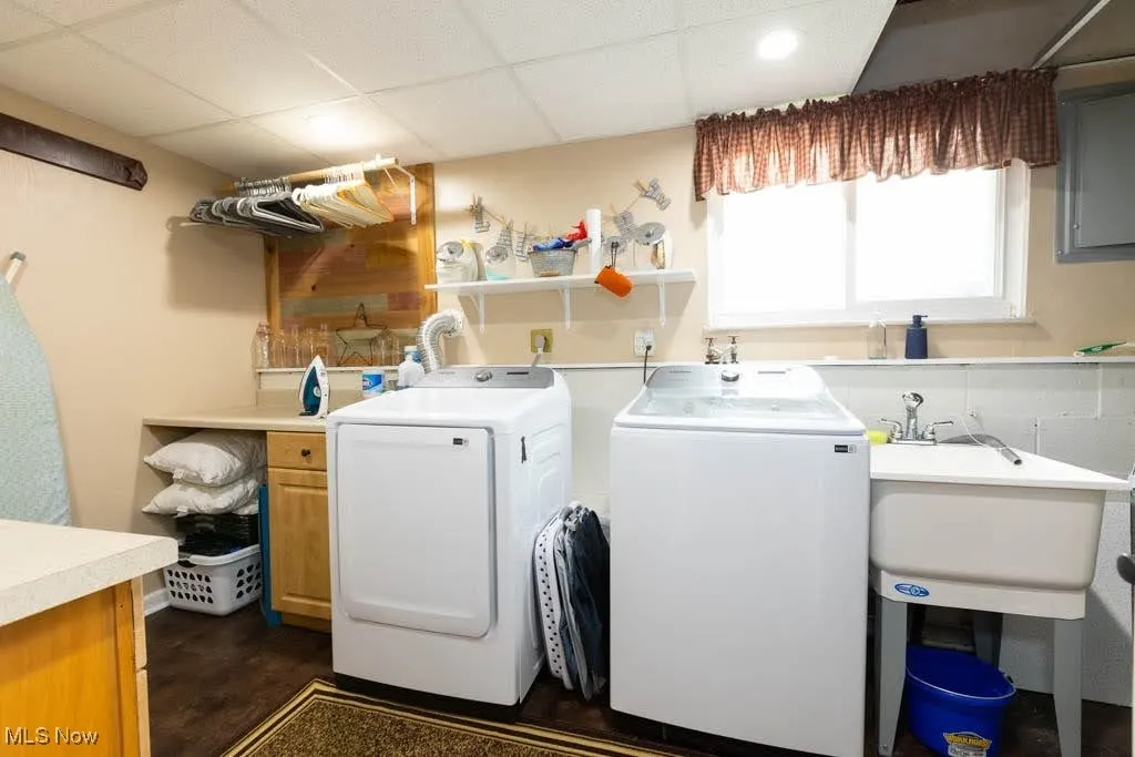 Laundry area featuring cabinet space, washing machine and clothes dryer, and electric panel