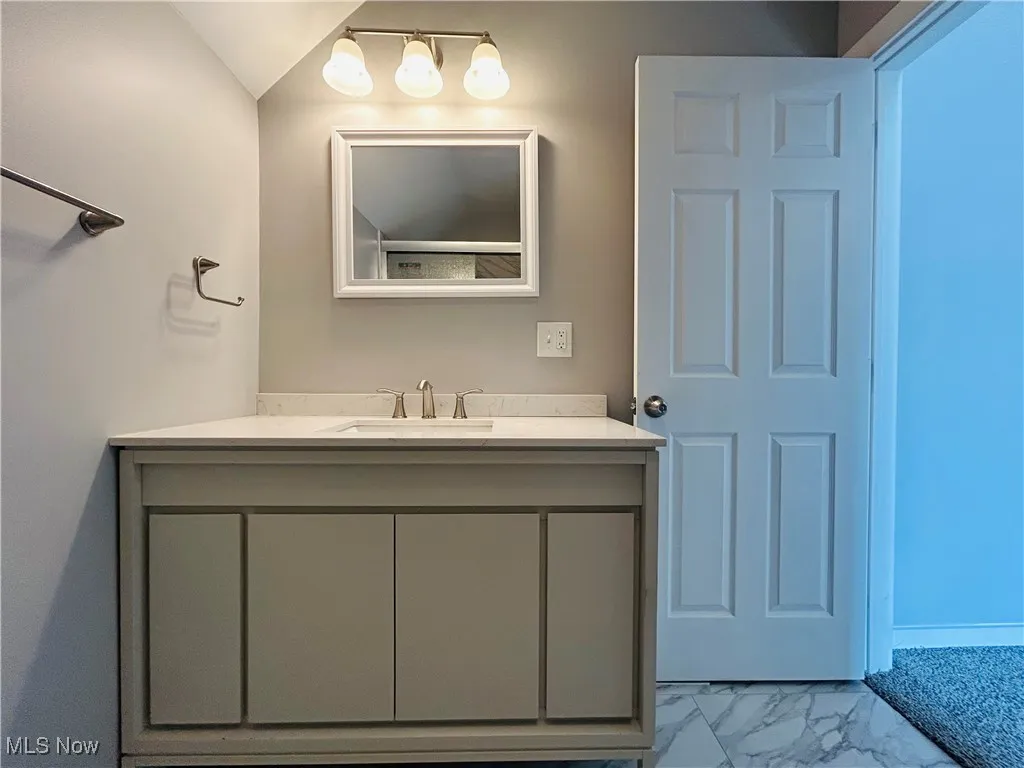 Bathroom with marble look tiles and vanity