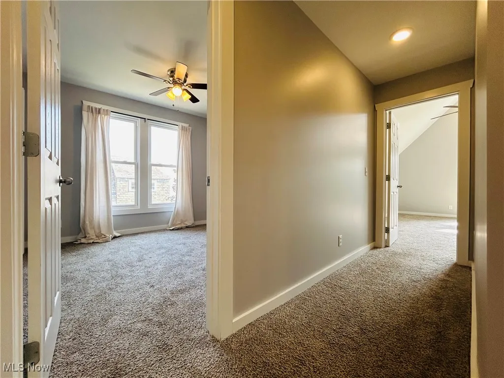 Corridor featuring carpet floors and vaulted ceiling