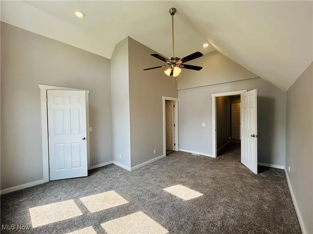 Unfurnished bedroom featuring carpet, recessed lighting, high vaulted ceiling, and a ceiling fan