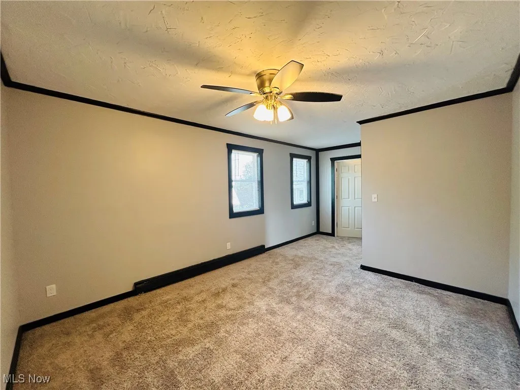 Spare room with light carpet, ornamental molding, a textured ceiling, and ceiling fan, additional living suite.