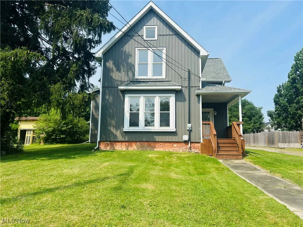 View of front of house featuring roof with shingles and board and batten siding