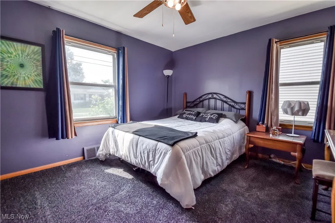 Carpeted bedroom with baseboards and a ceiling fan