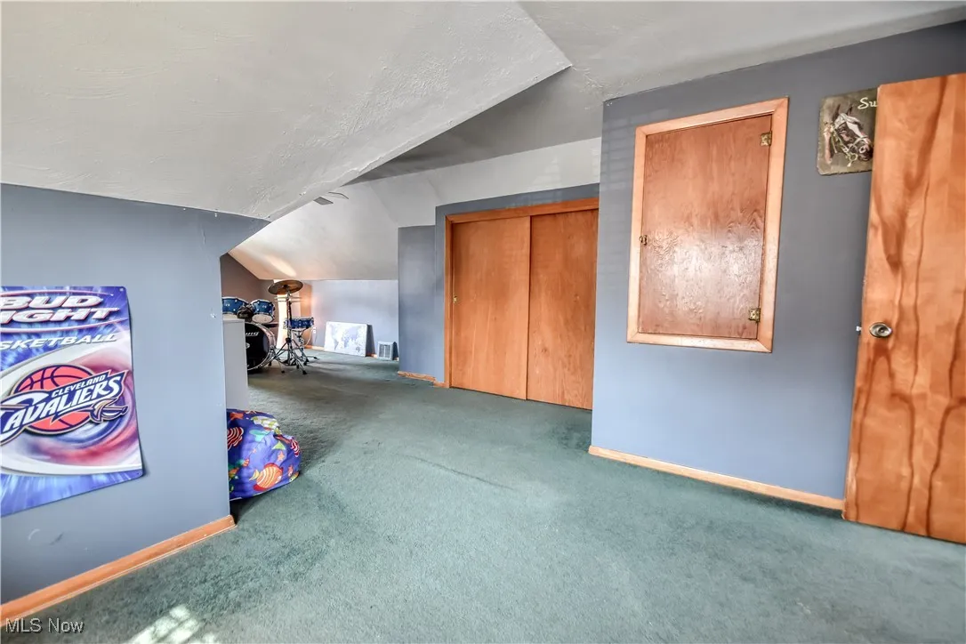 Bonus room with carpet flooring and lofted ceiling