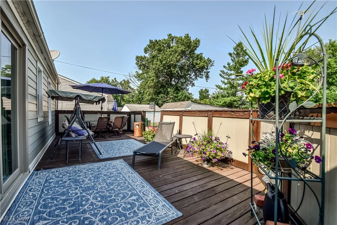 Wooden deck with a fenced backyard and outdoor dining space
