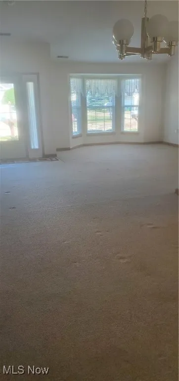 Unfurnished room with carpet floors and baseboards
