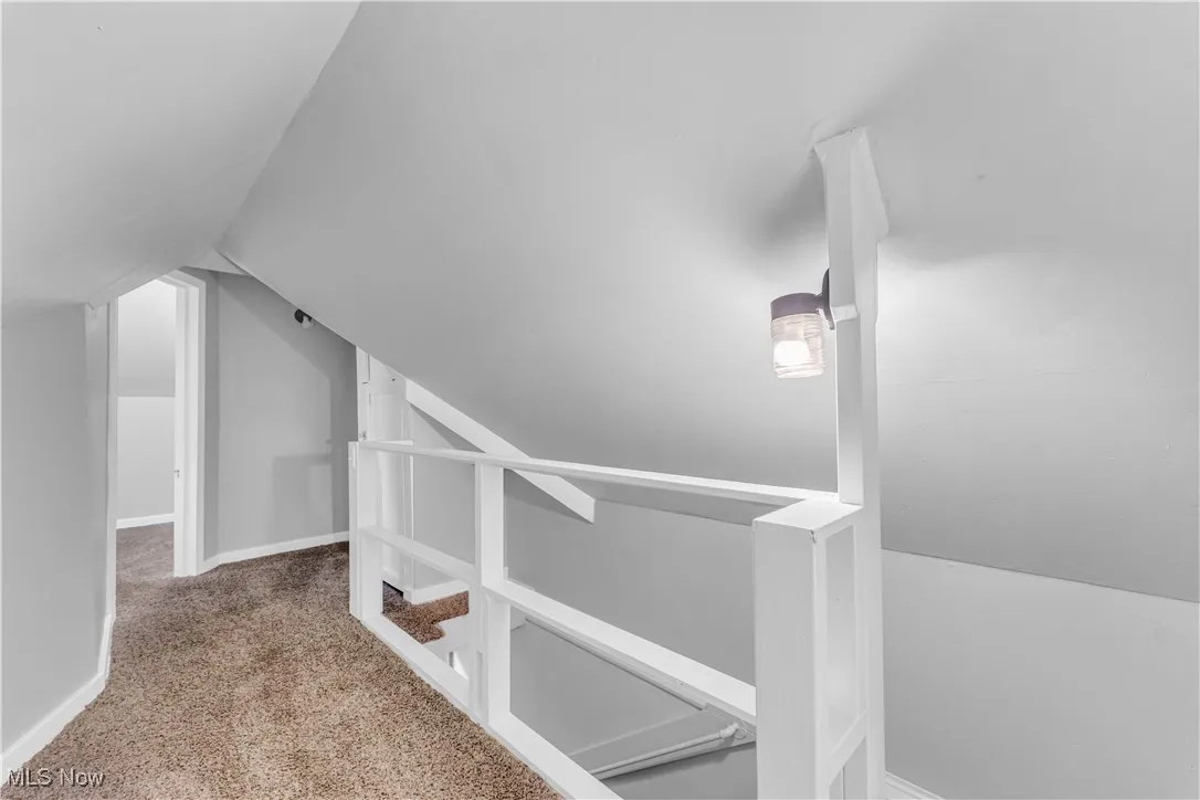 Additional living space with carpet and vaulted ceiling