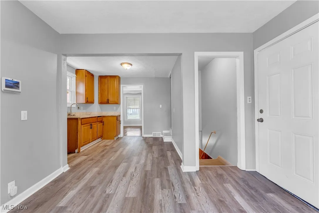 Kitchen featuring brown cabinetry, light countertops, and wood finished floors