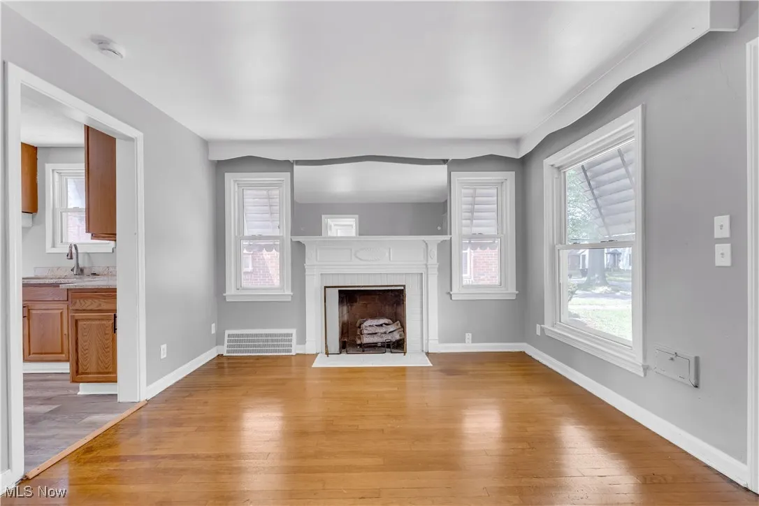 Unfurnished living room featuring light wood-style floors and a fireplace with flush hearth