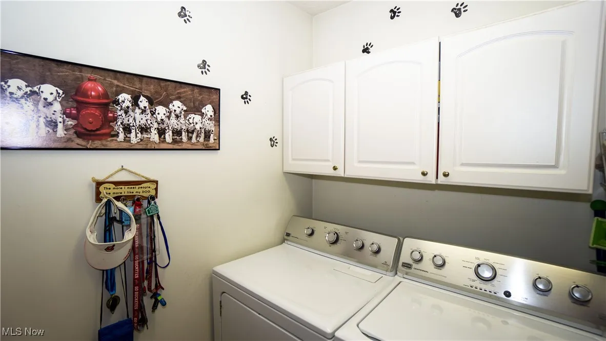 Washroom featuring washer and clothes dryer and cabinet space