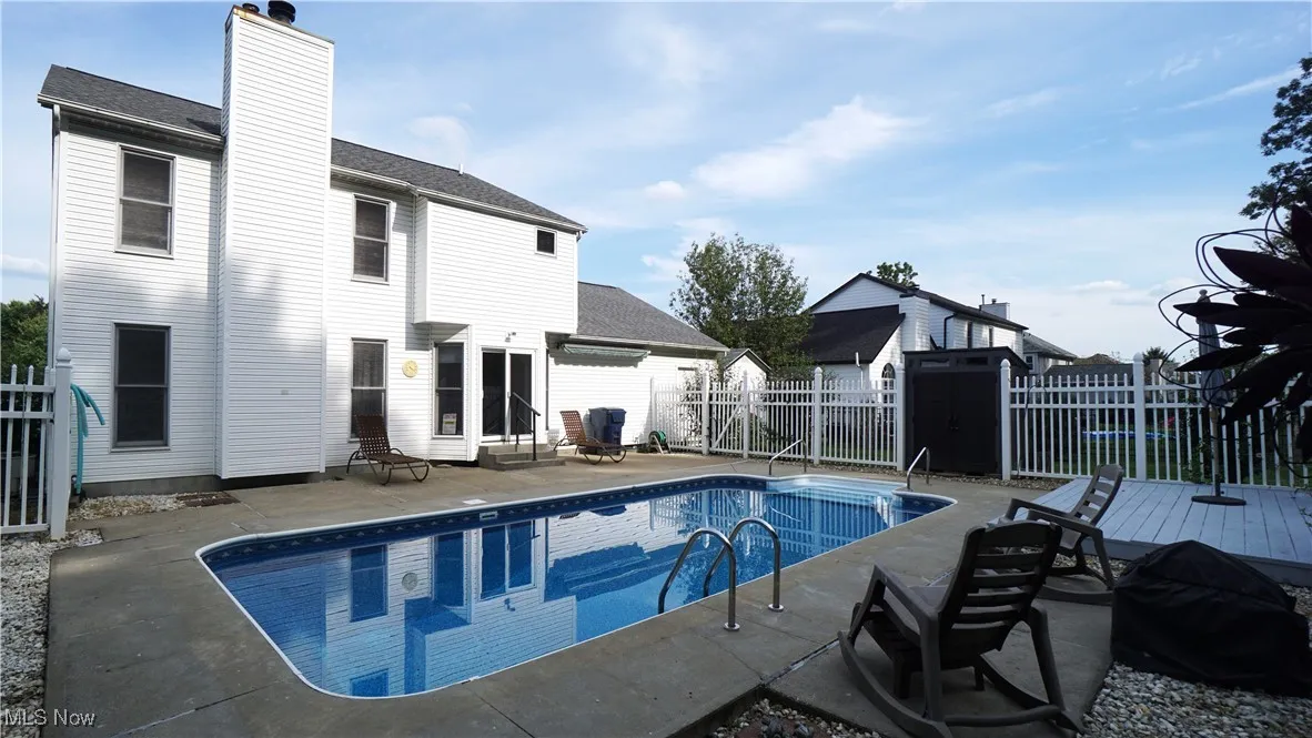 View of pool featuring entry steps, a fenced backyard, and a patio area