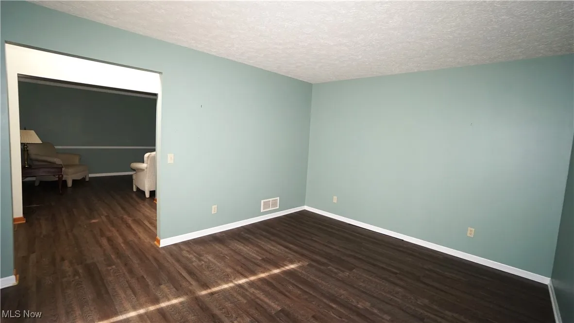 Office with dark wood-style flooring and a textured ceiling
