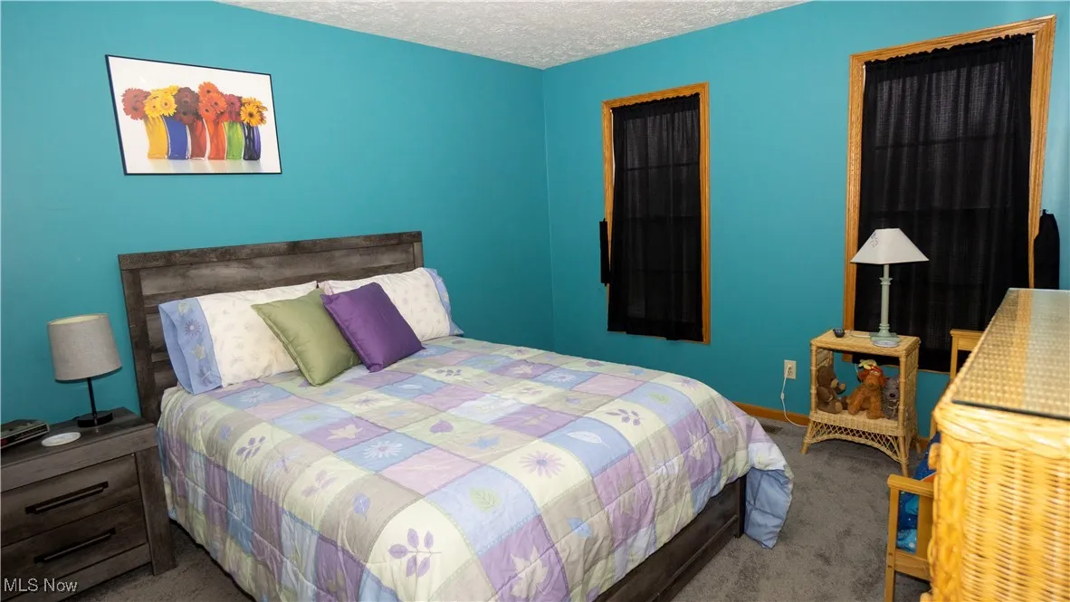 Bedroom featuring a textured ceiling and carpet flooring