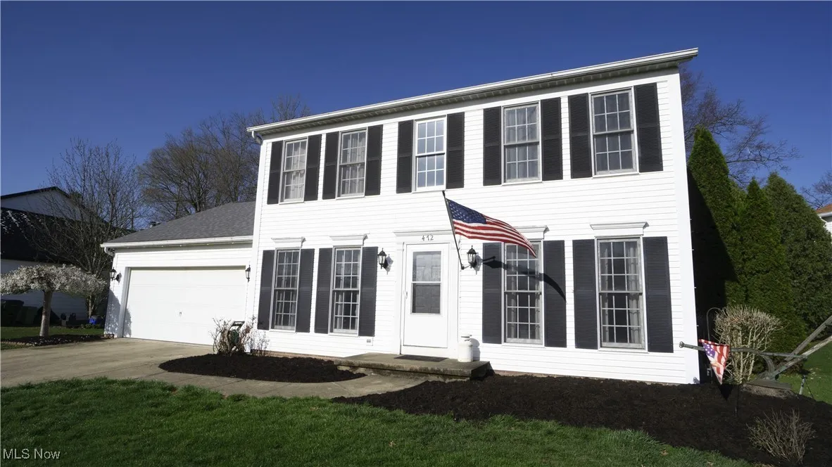 Colonial home featuring driveway and a garage